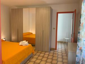 een slaapkamer met een oranje bed en een kast bij Al numero 5 in Francavilla di Sicilia