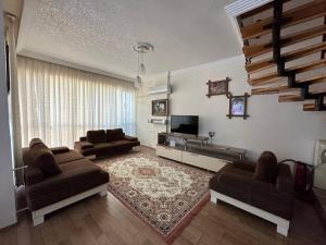 ein Wohnzimmer mit 2 Sofas und einem TV in der Unterkunft Kundu'da Havuzlu Bahçeli Villa in Antalya