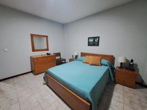 a bedroom with a bed and a dresser and a mirror at Quarto amplo do apartamento no Palmarejo in Praia