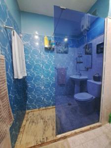 a bathroom with a shower with a toilet and a sink at Quarto amplo do apartamento no Palmarejo in Praia