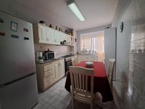 kuchnia ze stołem i białą lodówką w obiekcie Quarto amplo do apartamento no Palmarejo w mieście Praia