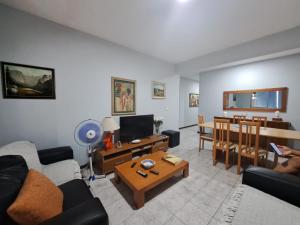 salon z kanapą i stołem w obiekcie Quarto amplo do apartamento no Palmarejo w mieście Praia