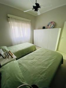 een slaapkamer met 2 bedden en een plafondventilator bij Lacheli in Santa Rosa