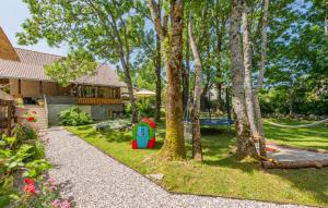a house with a yard with trees and a playground at Lika holiday home Mazini in Gračac