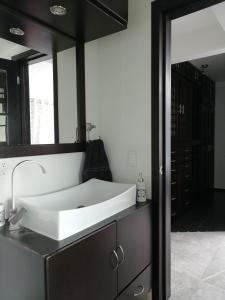 ein Badezimmer mit einem weißen Waschbecken und einem Spiegel in der Unterkunft Totonaca - Seguridad, 10min de Centros Comerciales & Zona Esmeralda - Empresas bienvenidas in Mexiko-Stadt