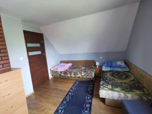 Habitación pequeña con 2 camas y puerta en U Romaniuków en Werstok