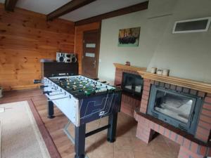 a living room with a foosball table and a fireplace at U Romaniuków in Werstok