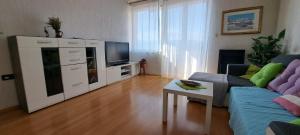 a living room with a couch and a tv at Liburana Apartment in Rijeka