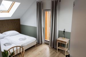 sypialnia z łóżkiem, stołem i oknem w obiekcie Domy Wypoczynkowe Diana w mieście Porosiuki