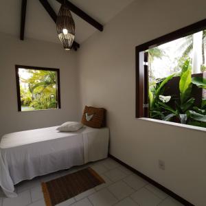 um quarto com uma cama e uma grande janela em Lagoa dourada - Ilha de Itaparica - Salvador da Bahia - Club Med em Vera Cruz de Itaparica