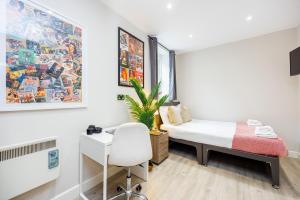 Schlafzimmer mit einem Bett, einem Schreibtisch und einem Stuhl in der Unterkunft Quality Spitalfields Accommodations in London