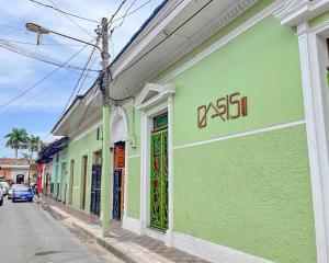 a green and white building on the side of a street at Oasis Hostel in Granada