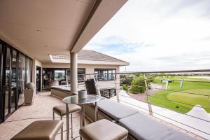 a balcony with a view of a golf course at Sunset Golf Villa in Langebaan