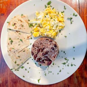 a plate of food with tacos and eggs and chips at Oasis Hostel in Granada