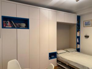 a bedroom with white cabinets and a bed at Studio Marais Notre Dame in Paris