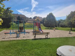 a park with a playground with a slide and a bench at Le Flocon, Superbe Cocon Montagnard en Rez de Jardin, Draps inclus et arrivée autonome in Les Rousses