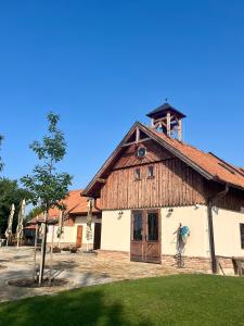 un grand bâtiment en bois avec une tour d'horloge en haut dans l'établissement Zámeček - Chateau Lány, à Břeclav