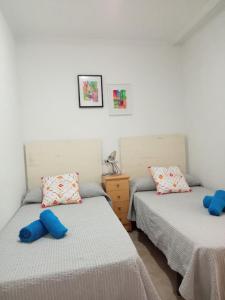 サンタ・ポラにあるAltos del Marの青い枕が備わる客室内のベッド2台
