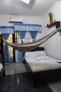 eine Hängematte, die über einem Bett in einem Zimmer hängt in der Unterkunft Hostal Castañeda in San José del Guaviare