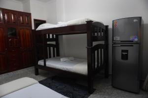 a room with three bunk beds and a television at Hostal Castañeda in San José del Guaviare