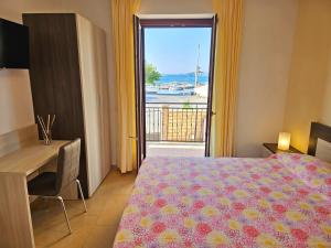 a bedroom with a bed and a desk and a window at Terrazza Vista Lago in Capodimonte