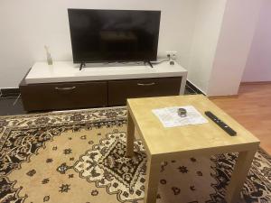 a living room with a tv on a dresser with a coffee table at Destiny apartment in Bratislava