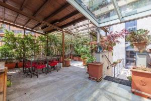 un patio con mesa, sillas y plantas en Noisette Casa con giardino en Milán
