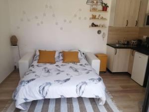 ein Schlafzimmer mit einem weißen Bett mit zwei Kissen in der Unterkunft Studio Les petites poules in Saint-Lyphard