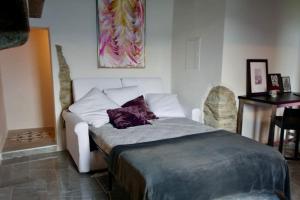 - une chambre avec un lit blanc et un oreiller violet dans l'établissement Favola sul lago, à Brissago