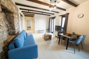 a living room with a blue couch and a table at Lithic Suites 1 in Kalabaka