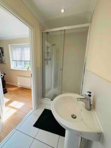 a white bathroom with a shower and a sink at Astor house Maidstone long stay in Maidstone
