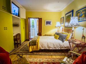 Dormitorio amarillo con cama y escritorio en The Tuscan Garden, en Newcastle