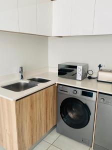 a kitchen with a sink and a washing machine at The blyde-Luxury one bedroom apartment in Pretoria