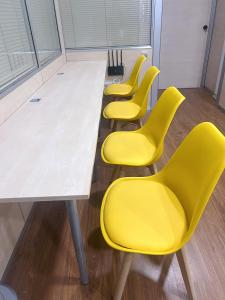 una fila de sillas amarillas en una sala de espera en Hostel Acacias en Madrid
