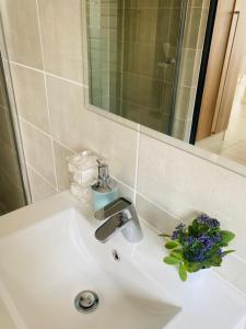 um lavatório de casa de banho com um vaso de flores em The blyde-Luxury one bedroom apartment em Pretoria