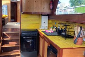 uma cozinha com um fogão e uma bancada em L'Amazone - bateau sur le canal de bourgogne em Tanlay