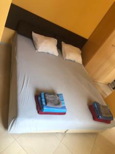 ein Bett mit drei Kissen und Handtüchern darauf in der Unterkunft White House in Plewen