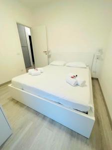 ein großes weißes Bett in einem Zimmer mit Spiegel in der Unterkunft Casa al Lago Leone d'Oro in Peschiera del Garda