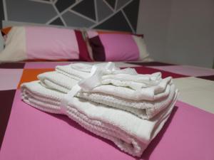 una pila de toallas sentadas encima de una cama en Stabia House, en Parma