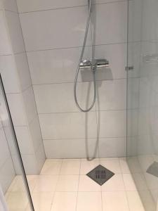 a shower stall with a metal box on the floor at Larvik appartment in the city in Larvik