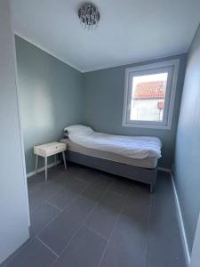 Larvik appartment in the city في لارفيك: غرفة نوم صغيرة بها سرير ونافذة