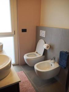 bagno con servizi igienici bianchi e lavandino di Residence Monza Parco a Lissone
