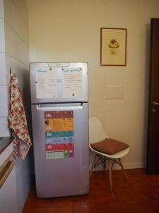 un frigorifero in cucina con una sedia accanto di Residence Monza Parco a Lissone