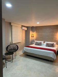 a bedroom with a large bed and a chair at Hotel Buena Vista Express in Bucaramanga +66 photos