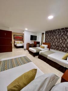 a hotel room with two beds and a tv at Hotel Buena Vista Express in Bucaramanga