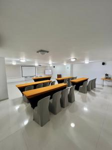 una sala conferenze con tavoli e sedie in legno di Hotel Buena Vista Express a Bucaramanga