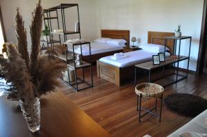 Cette chambre comprend deux lits, une table et des chaises. dans l'établissement Timber Guest House, à Berat