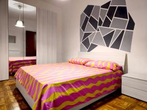 um quarto com uma cama com uma colcha colorida em Stabia House em Parma