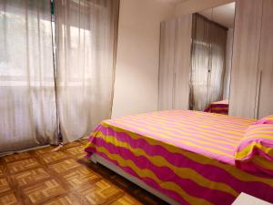 um quarto com uma cama com um cobertor listrado em Stabia House em Parma