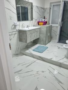 La salle de bains blanche est pourvue d'un lavabo et d'un miroir. dans l'établissement Appartamento con ingresso indipendente, à Nola